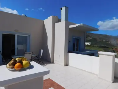 a bowl of fruit on the balcony of a house at Panoramic Balos Sea View House in Kissamos