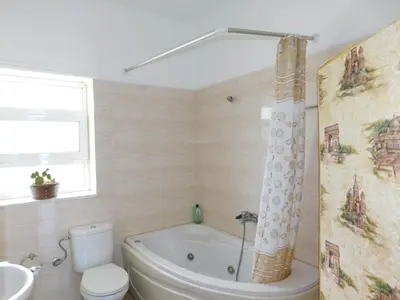 a bathroom with a tub and a toilet and a sink at Panoramic Balos Sea View House in Kissamos