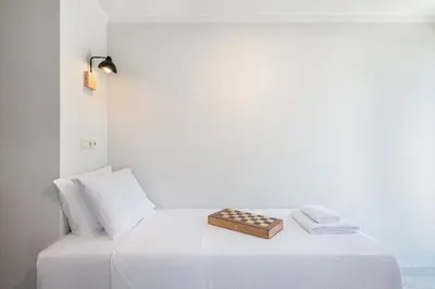 a white bed with a chess board on it at Trialonia Luxury Villa in Kissamos