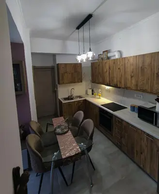 a kitchen with wooden cabinets and a table and chairs at A Pleasant Stay in Chania in Chania Town
