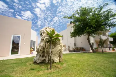 a rock in the grass in front of a house at Arodamos Studios & Apts in Kissamos
