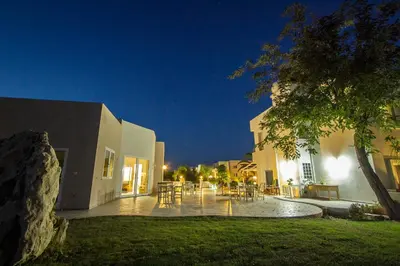 a courtyard of a house with tables and chairs at night at Arodamos Studios & Apts in Kissamos