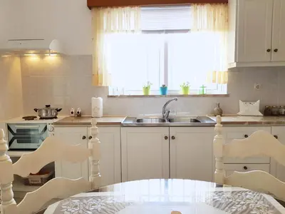 a kitchen with a table and a sink at Terra Falasarna in Falasarna