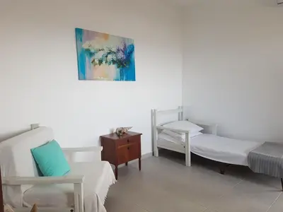 a bedroom with two beds and a painting on the wall at Terra Falasarna in Falasarna