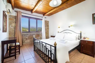 a bedroom with a bed and a large window at 4-bedroom Topolia House in Topólia