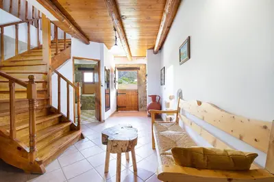 a living room with wooden stairs and a table at 4-bedroom Topolia House in Topólia