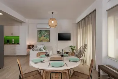 a dining room and living room with a table and chairs at Villa Kambos Platanias in Plataniás