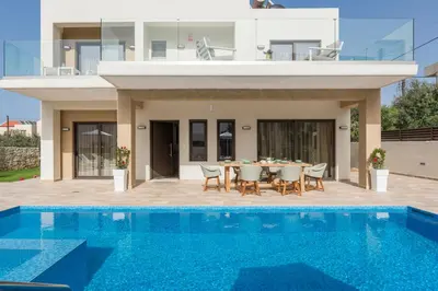 a villa with a swimming pool and a house at Villa Kambos Platanias in Plataniás