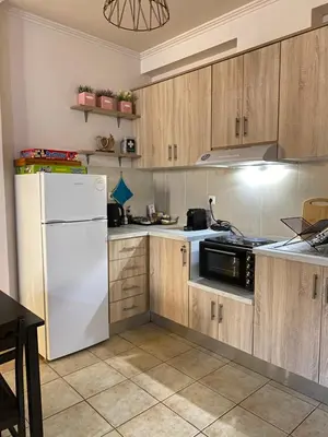a kitchen with a white refrigerator and wooden cabinets at Villa Pandora - Petit Bonheur in Maleme