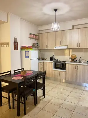 a kitchen with a table and chairs and a refrigerator at Villa Pandora - Petit Bonheur in Maleme
