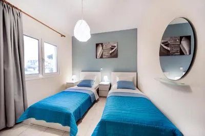 two beds in a room with a mirror at Omega Comfy Apartments in Almirida