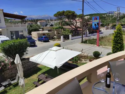 a white umbrella sitting on a balcony with a street at Omega Comfy Apartments in Almirida