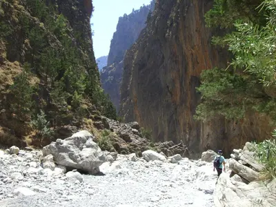 a person walking down a rocky river in a canyon at Omega Comfy Apartments in Almirida