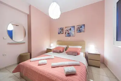 a bedroom with a bed with two pillows and a mirror at Omega Comfy Apartments in Almirida