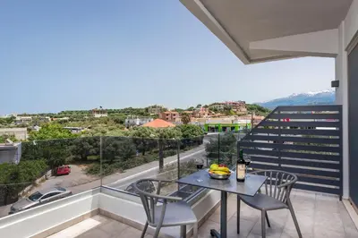 a balcony with a table and chairs and a view at Aequor Luxury Rooms & Apartments in Kato Daratso
