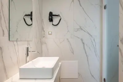 a white bathroom with a sink and a mirror at Aequor Luxury Rooms & Apartments in Kato Daratso