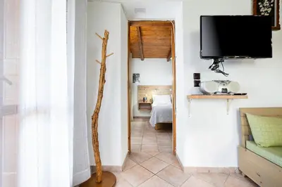 a hallway with a tv and a room with a bed at Topolia 1 Bedroom Villa in Topólia