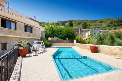 a swimming pool in front of a house at Topolia 1 Bedroom Villa in Topólia