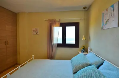 a bedroom with a blue bed and a window at Kalithea Studio Aptera in Megála Khoráfia
