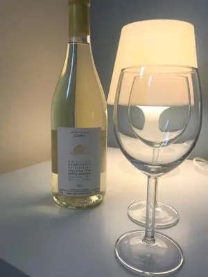 a bottle of wine next to a wine glass at Omega Comfy Apartments Almyrida in Almirida