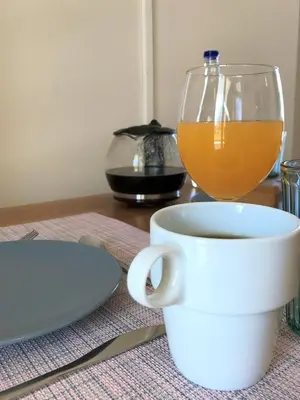 a cup of coffee and a glass of orange juice at Omega Comfy Apartments Almyrida in Almirida