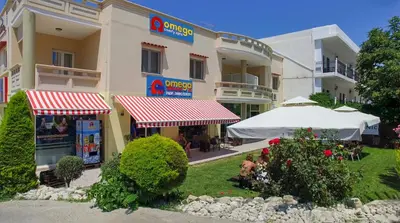 a building with a restaurant in front of it at Omega Comfy Apartments Almyrida in Almirida