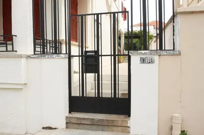 an open door of a house with a gate at Spacious townhouse close to Chania center in Chania Town