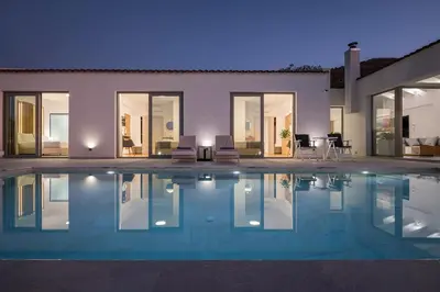 a house with a swimming pool in front of it at Villa White Harmony in Khámbatha
