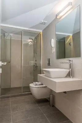 a bathroom with a sink and a toilet and a mirror at Creta Elena in Chania Town