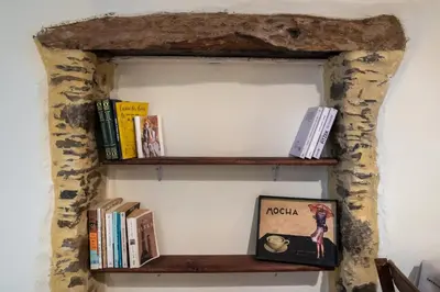 a shelf with books and a picture on a wall at Feneri- cozy Apartment 20' from Elafonisi beach in Elafonisi