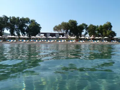 a view of a beach with chairs and umbrellas at Cormoranos Apartments Rooms Eco Green in Kissamos