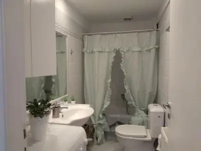 a white bathroom with a sink and a toilet at Diamant's Place with Treehouse Garden in Kounoupidhianá