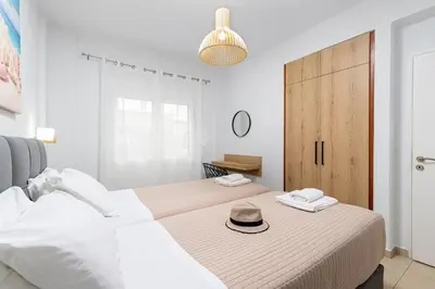 a bedroom with a bed with a hat on it at Sun Beach Apartments in Kato Daratso