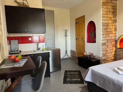 a kitchen with a sink and a table in a room at Aristos Apartments & Suites in Stalos
