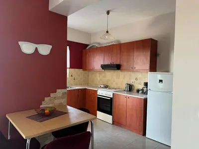 a kitchen with a table and a white refrigerator at Aristos Apartments & Suites in Stalos