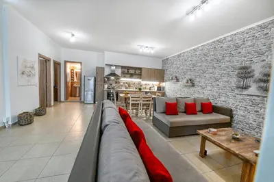 a living room with a couch and a brick wall at Stelios & Stavros Apartment in Kissamos