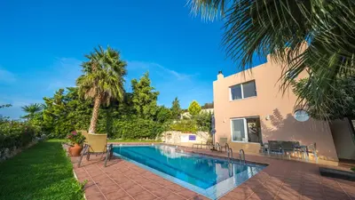 a swimming pool in front of a house at Meliades Villas in Agia Marina Nea Kydonias