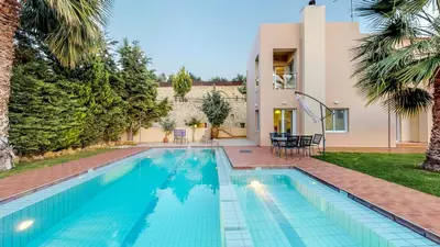 a swimming pool in the backyard of a house at Meliades Villas in Agia Marina Nea Kydonias