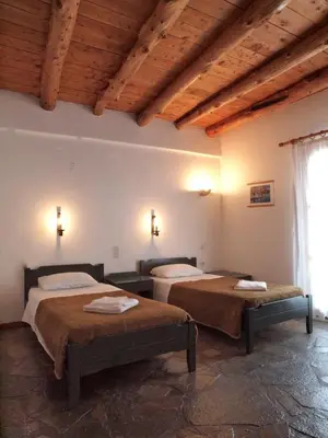 two beds in a room with wooden ceilings at Villa Niki in Loutro