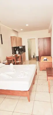 a bedroom with a large white bed in a room at Kalimera Hotel in Agia Marina Nea Kydonias
