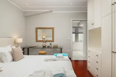 a white bedroom with two beds and a desk at Villa Tranquilla in Kolymvari