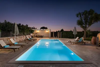 a swimming pool in a backyard at night at Villa Tranquilla in Kolymvari