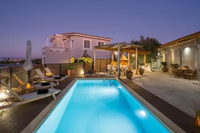 a swimming pool in a backyard with a house at Villa Roxanne in Galatás