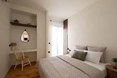 a bedroom with a bed and a chair and a window at MV Living - Retreat in Daratso