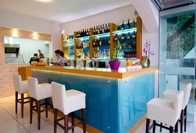 a blue bar with white stools in a restaurant at Frida Apartments in Chania Town