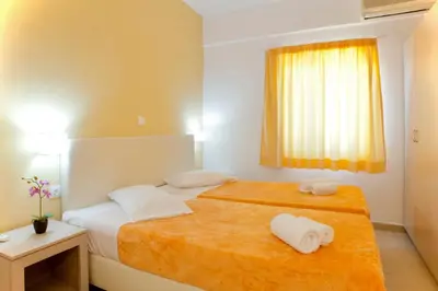 a hotel room with two beds and a window at Frida Apartments in Chania Town