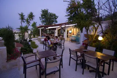 a group of people sitting at tables on a patio at Frida Apartments in Chania Town