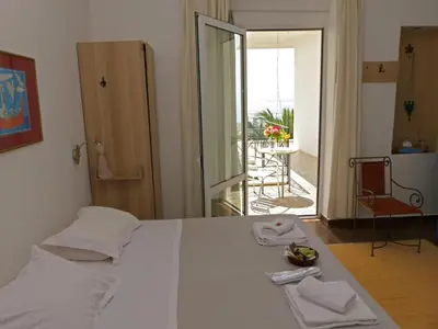 a bedroom with a bed with a view of a patio at Akrotiri Hotel in Chania Town