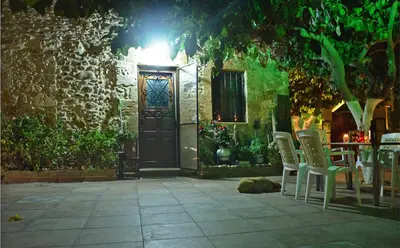 a door to a building with chairs and a table at Kamara Stone House in Kissamos