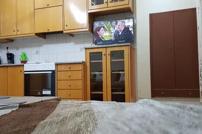 a kitchen with a flat screen tv on the wall at Enjoy Sunset in Palaiochóra